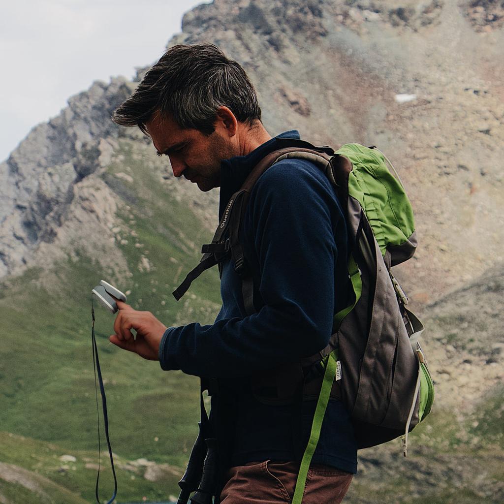 man hiking in CO mountains and checking is pulse and oxygen levels