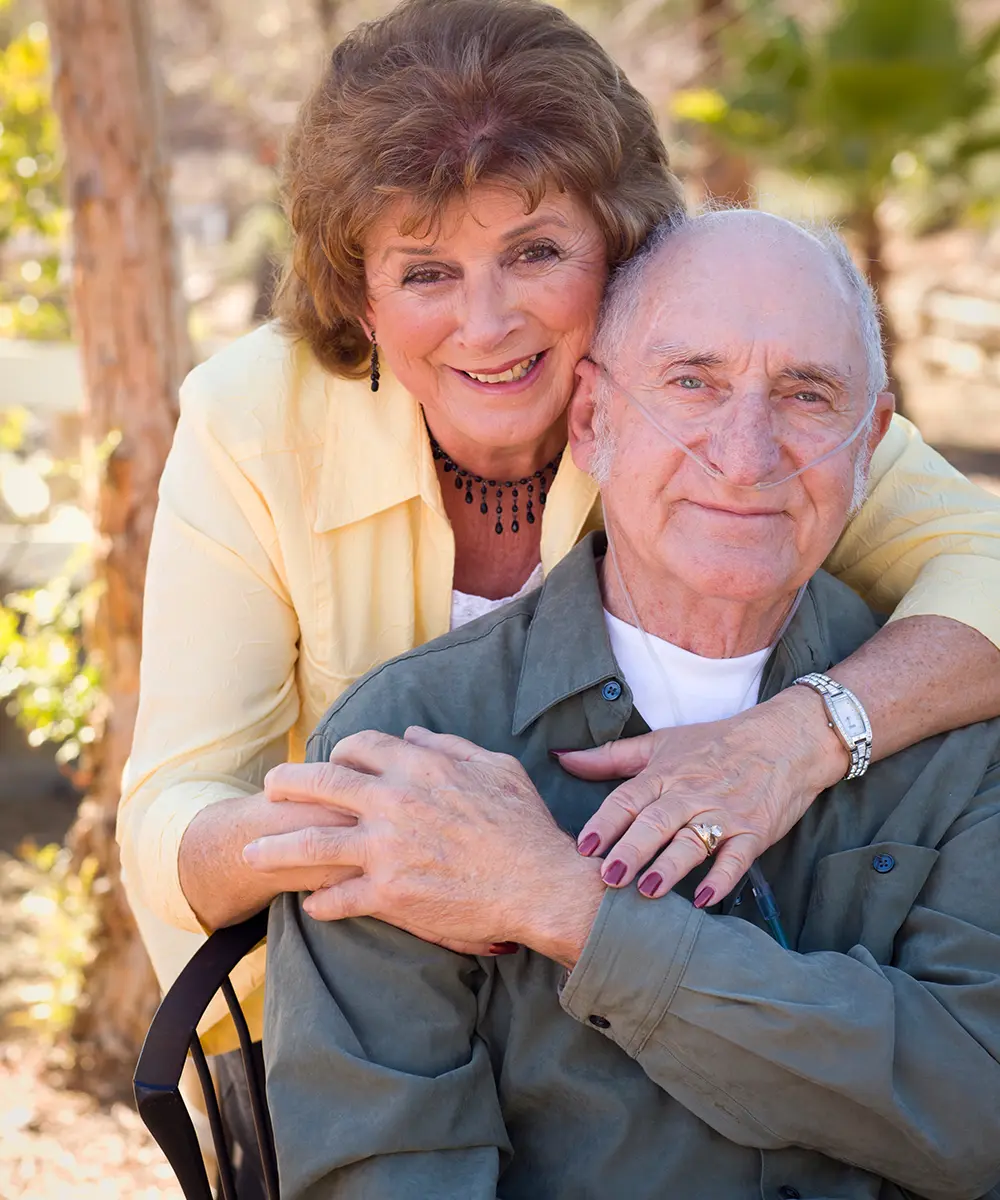man sitting on park bench outdoors with oxygen